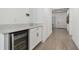 Bright hallway with wood-look floors leading to the entrance, featuring a beverage cooler at 9802 Carabiner Way, Land O Lakes, FL 34637