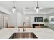 Bright kitchen featuring a large island with pendant lighting and stainless steel sink at 9802 Carabiner Way, Land O Lakes, FL 34637