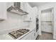 Modern kitchen showcasing a cooktop, a stainless steel range hood, a microwave, and an oven at 9802 Carabiner Way, Land O Lakes, FL 34637