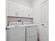 Functional laundry room with overhead cabinets and modern washer and dryer units at 9802 Carabiner Way, Land O Lakes, FL 34637