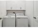 Convenient laundry room featuring side-by-side washer and dryer and overhead cabinets at 9802 Carabiner Way, Land O Lakes, FL 34637