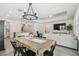 Open-concept living and dining area featuring a chandelier, TV, and comfortable seating at 9802 Carabiner Way, Land O Lakes, FL 34637