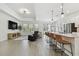 Bright open-concept living room with kitchen island, modern lighting, stainless appliances and tile floors at 9802 Carabiner Way, Land O Lakes, FL 34637