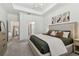 Bright main bedroom featuring a tray ceiling, chandelier, and en-suite bath at 9802 Carabiner Way, Land O Lakes, FL 34637