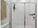 Modern shower with glass door and white subway tile, complemented by sleek fixtures at 9802 Carabiner Way, Land O Lakes, FL 34637