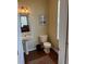 Cozy half bath with pedestal sink, framed art and a window view, perfect for guests at 10002 Bradwell Pl, Tampa, FL 33626
