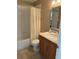 Well-lit bathroom with a shower, vanity and wood cabinets that offers both functionality and style at 10002 Bradwell Pl, Tampa, FL 33626
