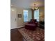 Cozy living room featuring a red chair, plush ottoman, and elegant area rug at 10002 Bradwell Pl, Tampa, FL 33626