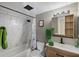 Updated bathroom featuring a shower-tub combo with a white tile surround, wooden vanity and modern fixtures at 1055 82Nd N Ter # 1055A, St Petersburg, FL 33702