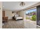 Bright bedroom featuring wood-look floors, a ceiling fan, and a sliding glass door with outside views at 1055 82Nd N Ter # 1055A, St Petersburg, FL 33702