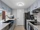 Updated kitchen with stainless steel appliances, granite countertops, and stylish gray cabinetry at 1055 82Nd N Ter # 1055A, St Petersburg, FL 33702