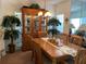 Dining room showcasing a wooden table set, elegant china cabinet, and decorative palm trees at 11351 Shipwatch Ln # 1840, Largo, FL 33774