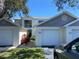 The exterior of this charming home boasts attached garages, a white facade, and vibrant landscaping at 11351 Shipwatch Ln # 1840, Largo, FL 33774