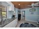 Kitchenette with white cabinetry, wood ceiling and adjacent entry to the bedroom at 1264 N Florida Ave, Tarpon Springs, FL 34689