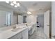 Bathroom featuring double sinks, a large mirror, a shower and view into an adjacent bedroom at 12851 Tortoise Shell Pl, Riverview, FL 33579
