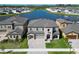 Stunning two-story home featuring stone accents, a paver driveway, manicured lawn, and a serene lake view at 12851 Tortoise Shell Pl, Riverview, FL 33579