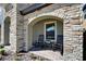 Inviting front porch with stone archway and comfortable rocking chairs, perfect for relaxing at 12851 Tortoise Shell Pl, Riverview, FL 33579