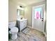 Neutral bathroom with gray cabinet and white door to backyard at 13633 Britton Dr, Hudson, FL 34667