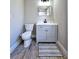 Cozy bathroom featuring a gray vanity with white countertop and a modern commode at 13633 Britton Dr, Hudson, FL 34667