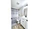 Cozy bathroom with black hardware and striped shower curtain at 13633 Britton Dr, Hudson, FL 34667