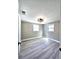 This bedroom has modern light fixture, two large windows, and light wood flooring at 13633 Britton Dr, Hudson, FL 34667