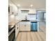 Kitchen featuring new appliances, black countertops, and floating wooden shelves at 13633 Britton Dr, Hudson, FL 34667