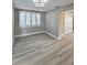 Sun-lit living area featuring light walls and laminate flooring at 13633 Britton Dr, Hudson, FL 34667