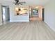 Open living area with light wood floors seamlessly flows into the adjacent kitchen at 13633 Britton Dr, Hudson, FL 34667