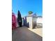 Outdoor gray shed is placed on a concrete platform next to a white fence under a bright blue sky at 13633 Britton Dr, Hudson, FL 34667