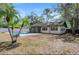Backyard featuring swimming pool, screened in patio, and surrounded by trees at 13969 Gull Way, Clearwater, FL 33762