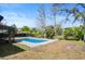 Backyard with mature trees, swimming pool, and patio area perfect for outdoor gatherings at 13969 Gull Way, Clearwater, FL 33762