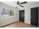 Bright bedroom featuring Luxury Vinyl Plank flooring, black closet doors and a modern ceiling fan at 13969 Gull Way, Clearwater, FL 33762