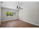 Bright bedroom with wood floors, ceiling fan, and a large window overlooking lush landscaping at 13969 Gull Way, Clearwater, FL 33762