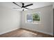Neutral bedroom featuring LVP flooring, modern ceiling fan, and large window at 13969 Gull Way, Clearwater, FL 33762
