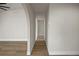 Inviting hallway featuring white walls, Luxury Vinyl Plank flooring, and archways at 13969 Gull Way, Clearwater, FL 33762
