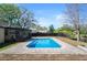Backyard pool with brick patio, lush trees and an enclosed patio area at 13969 Gull Way, Clearwater, FL 33762