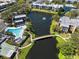 Stunning aerial view of a community with a pool, lake with fountain, clubhouse, and tennis courts at 14130 Rosemary Ln # 5206, Largo, FL 33774