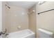 Bathroom featuring a bathtub with shower head and neutral colored tiles at 14130 Rosemary Ln # 5206, Largo, FL 33774