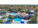 Aerial view of the resort-style pool with a waterfall and slide feature, surrounded by lush landscaping and palm trees at 15811 Fishhawk Falls Dr, Lithia, FL 33547