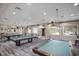 Well-lit billiard room features multiple pool tables, seating, and neutral decor at 16145 Amethyst Key Dr, Wimauma, FL 33598