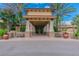 Elegant clubhouse entrance featuring stone pillars, covered walkway, and well-maintained landscaping at 16145 Amethyst Key Dr, Wimauma, FL 33598