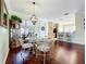 Cozy dining area featuring a chandelier, hardwood floors, and access to the kitchen, creating a warm and inviting atmosphere at 16145 Amethyst Key Dr, Wimauma, FL 33598