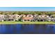 View of lakeside single-Gathering homes, each featuring a screened lanai and tropical landscaping at 16145 Amethyst Key Dr, Wimauma, FL 33598