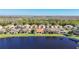 Scenic view of single-Gathering homes by the lake, showcasing well-manicured lawns and diverse rooflines at 16145 Amethyst Key Dr, Wimauma, FL 33598