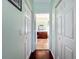 Hallway leads to a bathroom with a wood vanity and stone-look flooring, offering a private retreat at 16145 Amethyst Key Dr, Wimauma, FL 33598