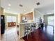 Open-concept kitchen featuring a breakfast bar, hardwood floors, and modern appliances at 16145 Amethyst Key Dr, Wimauma, FL 33598