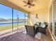 Screened-in patio featuring comfortable wicker furniture, overlooking serene lake view at 16145 Amethyst Key Dr, Wimauma, FL 33598