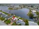 Aerial view of lakeside home with lush lawn, private boat dock, and serene waterfront setting, perfect for relaxation at 1710 New Bedford Dr, Sun City Center, FL 33573