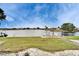 Manicured backyard with a grassy lawn leading to a waterfront with a private dock at 1710 New Bedford Dr, Sun City Center, FL 33573