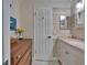 Bright bathroom showcasing white vanity, decorative mirror, and wood-look floors at 1710 New Bedford Dr, Sun City Center, FL 33573